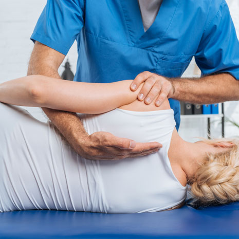 An image of a chiropractor adjusting a woman’s back