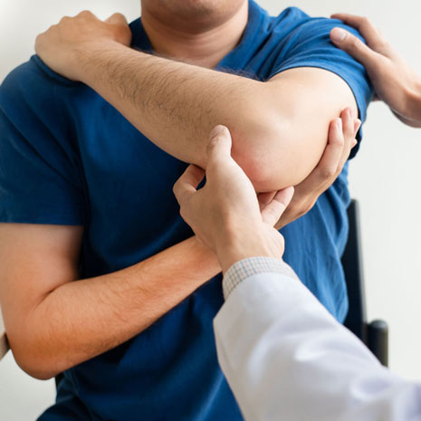 Chiropractor checking a man as he stretches his arm